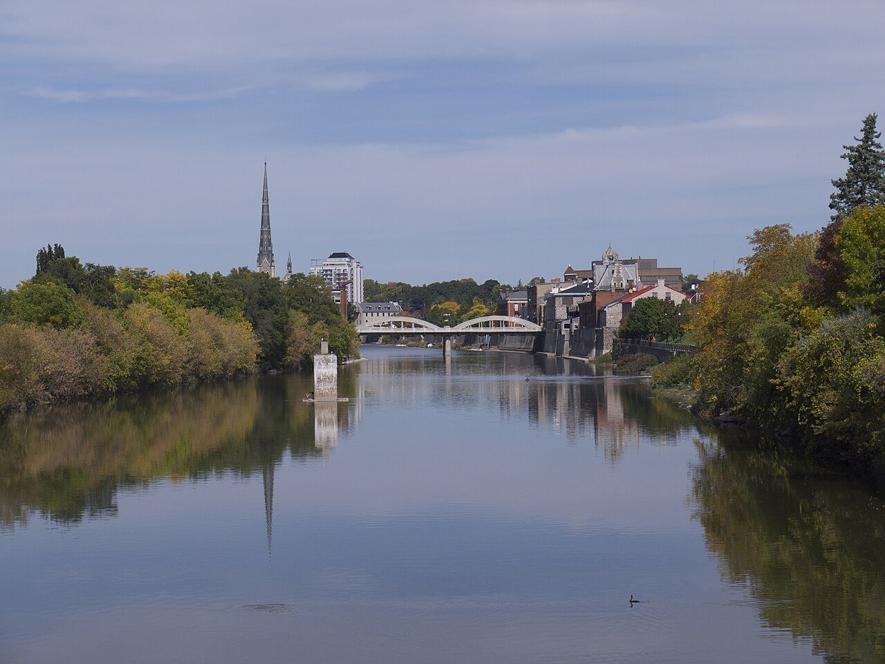 The Grand River flowing through Cambridge, with a church spire and bridge